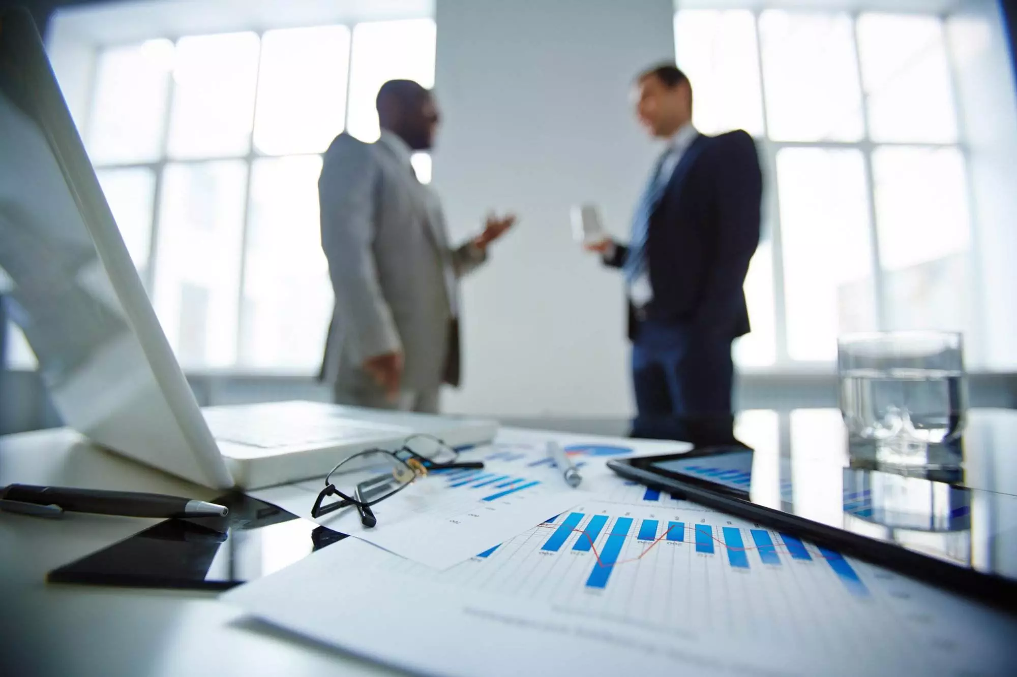 Businessmen discussing over documents in office.