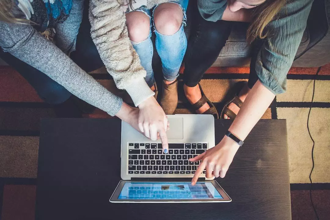 Three people collaborating over laptop