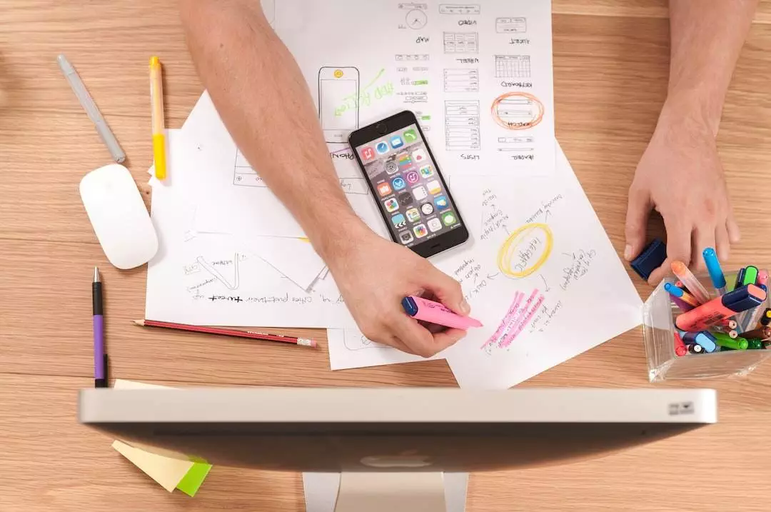 Person marking app design sketches on desk