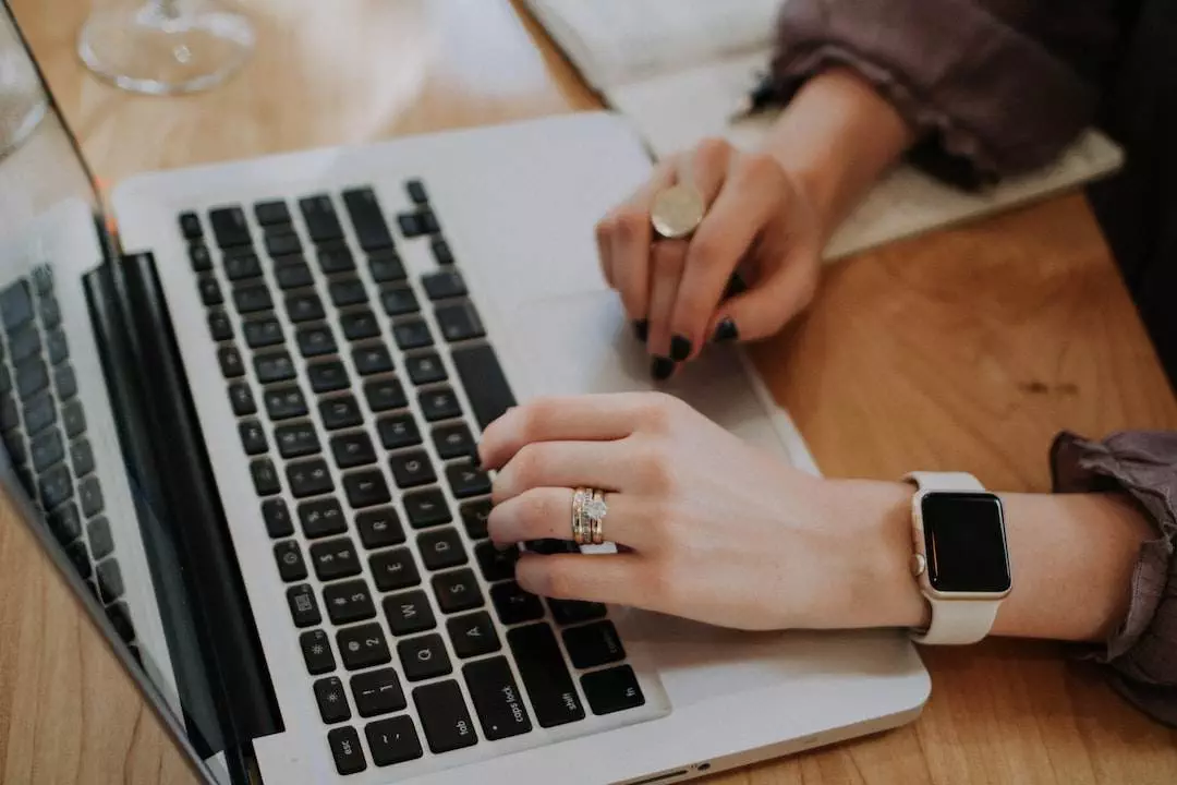 Person using laptop and wearing smartwatch.