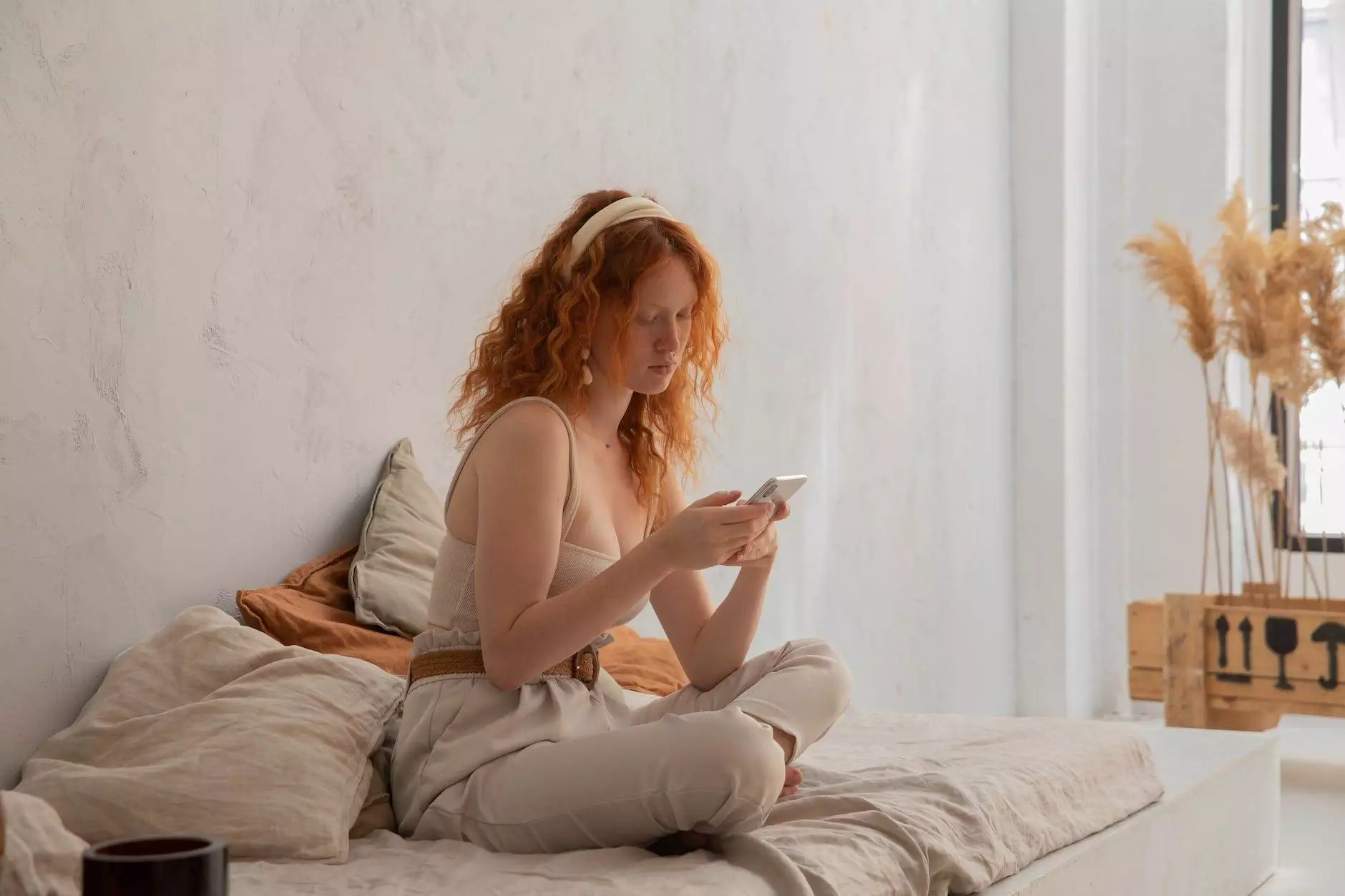 pensive redhead woman browsing smartphone