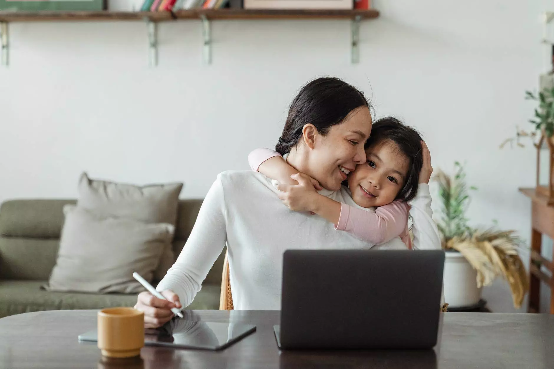 cute little ethnic girl embracing working mother