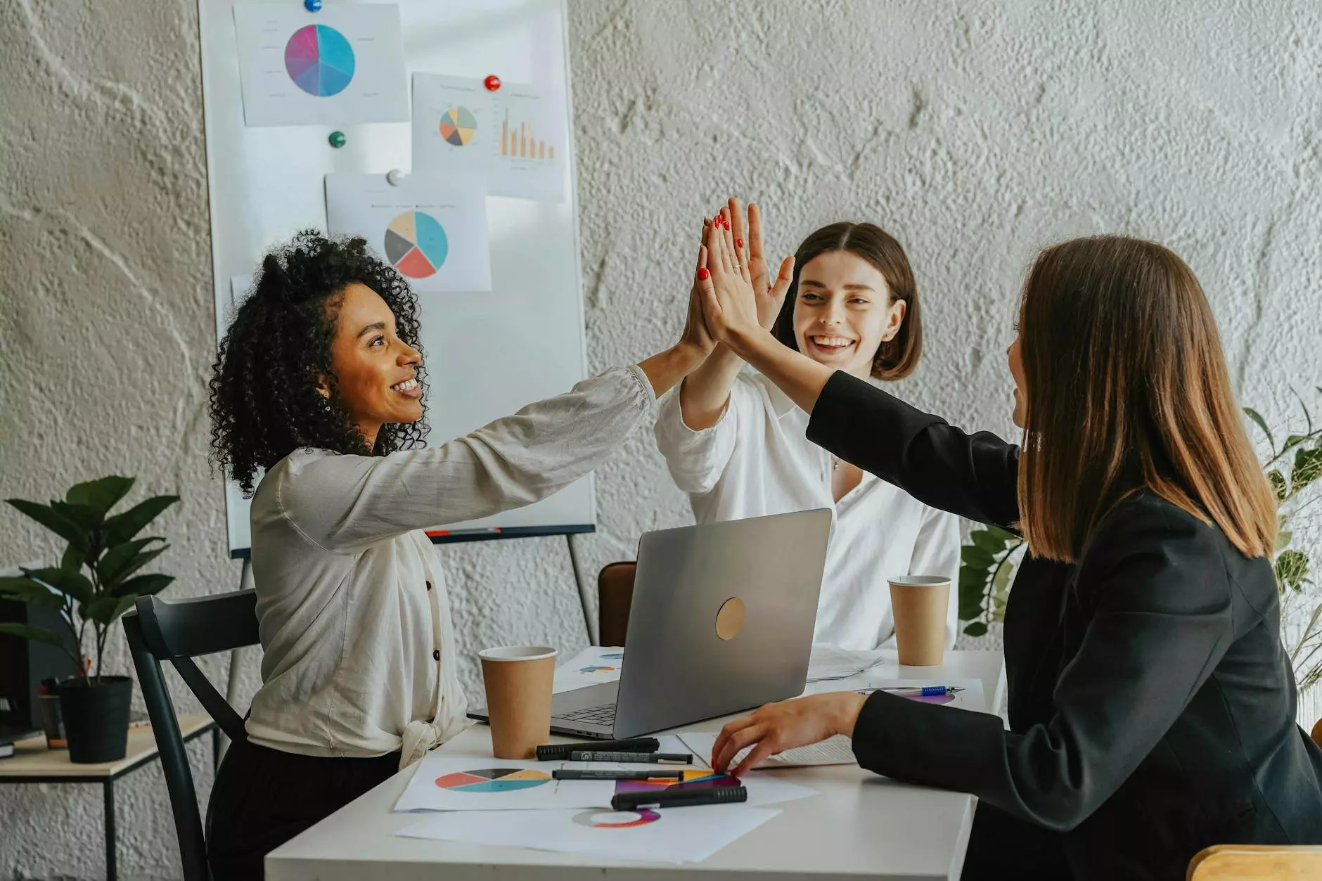 beautiful women sitting at a table giving high five