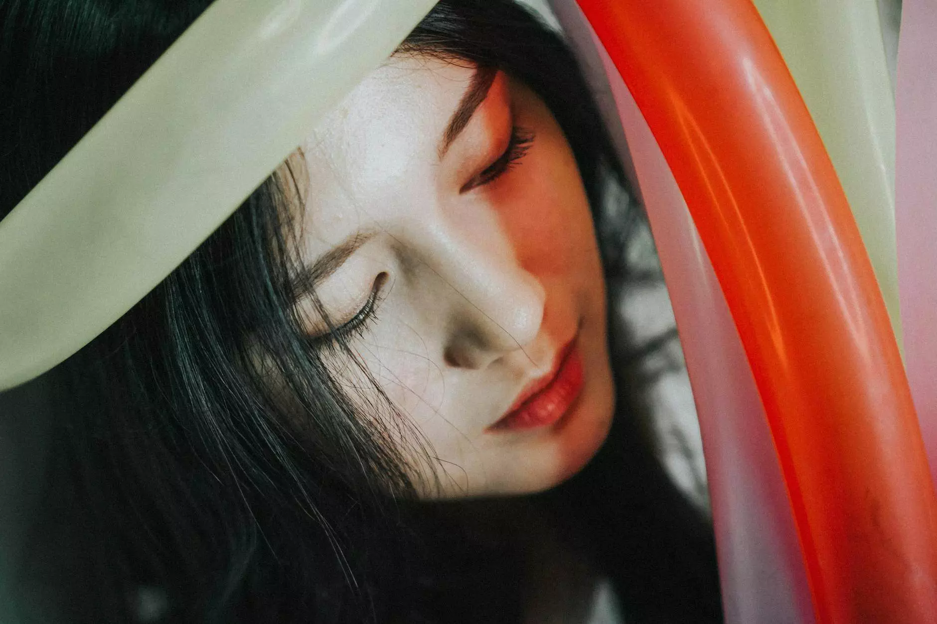 close up of a young woman holding colorful balloons