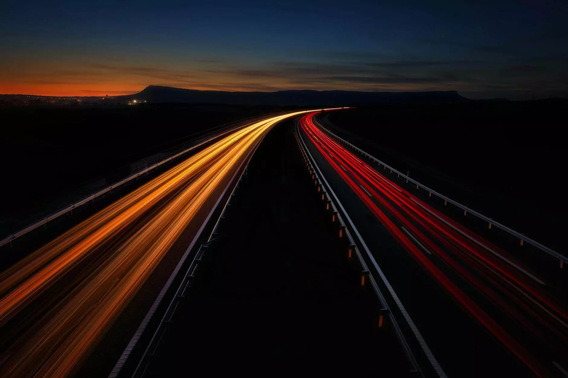 vehicle light trails on a remote highway at night